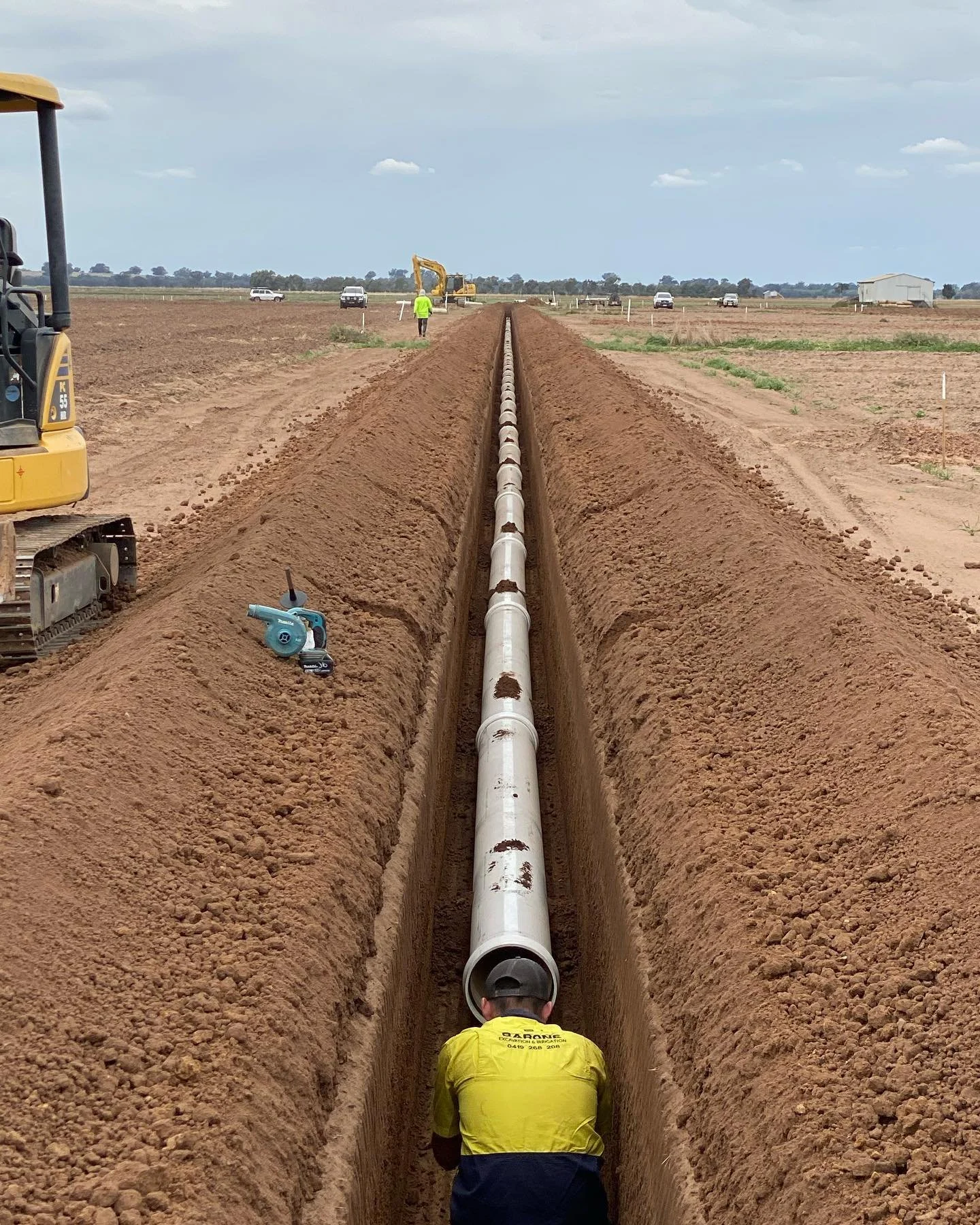 Barone team member working in a straight mainline trench on an agricultural project